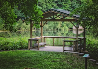 brown wooden gazebo near green trees during daytime