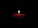 red lighted candle on dark room