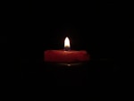 red lighted candle on dark room