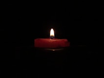 red lighted candle on dark room