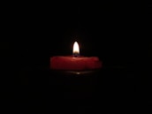 red lighted candle on dark room