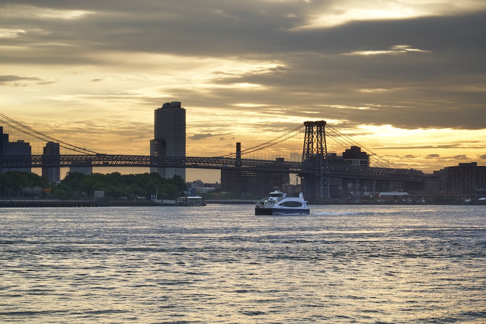 white boat on water near bridge during daytime