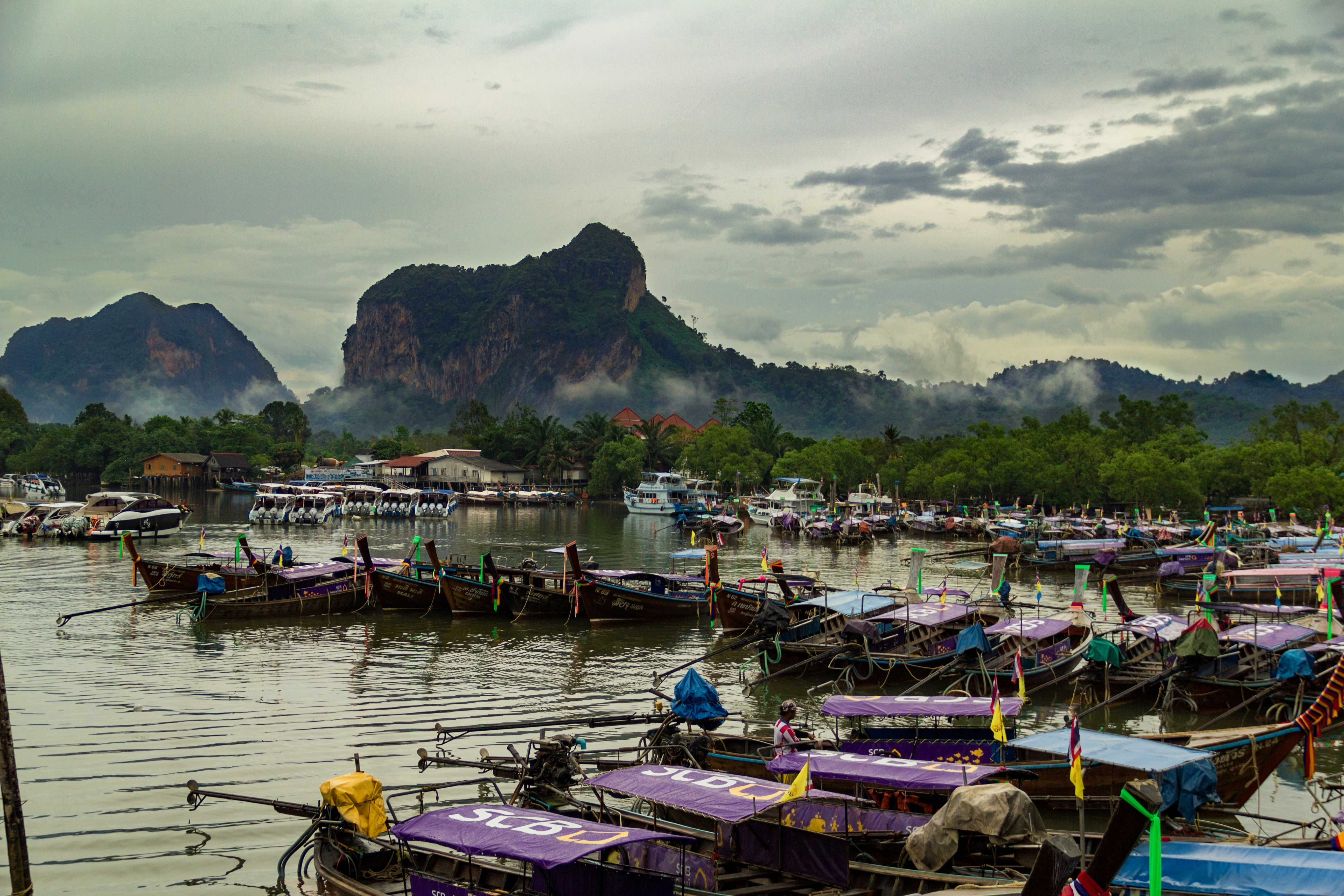 boats on dock near mountain during daytime, 