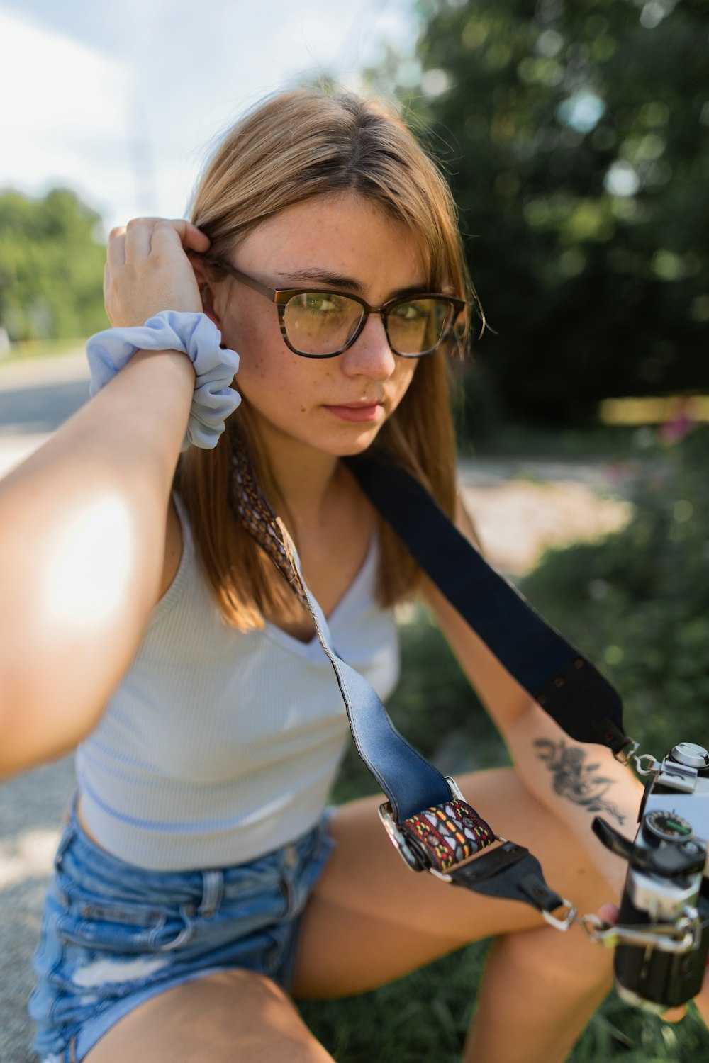 woman in white tank top wearing black framed eyeglasses