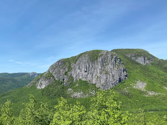 green and gray mountain under blue sky during daytime in Parc national des Grands-Jardins Canada