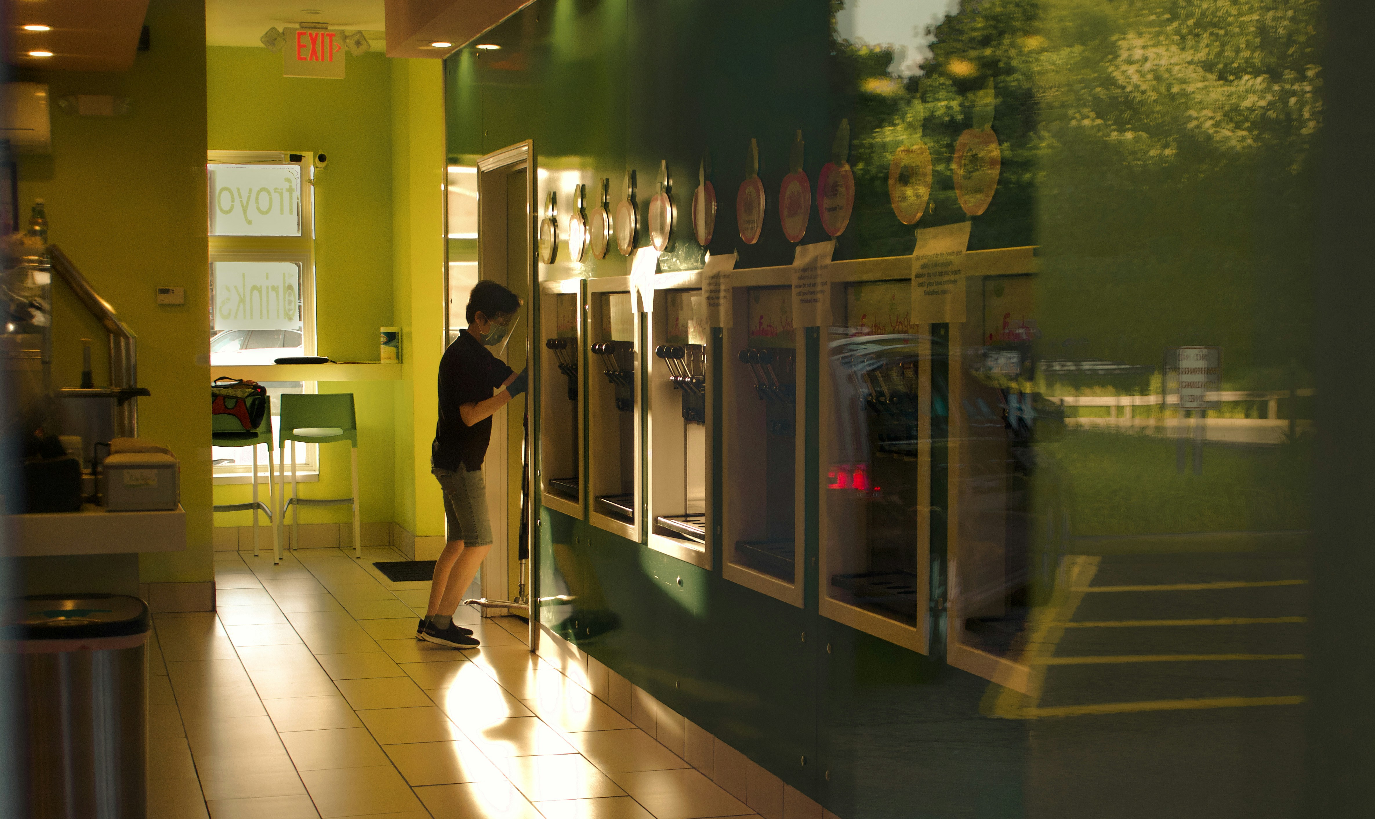 man in black t-shirt and black pants standing near glass door