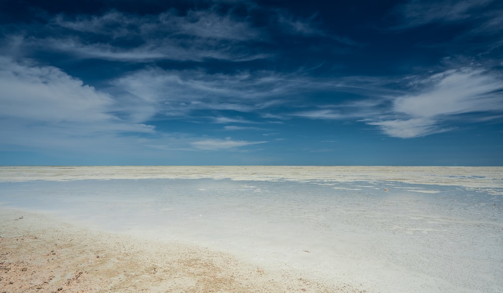 plage de sable blanc sous le ciel bleu pendant la journée