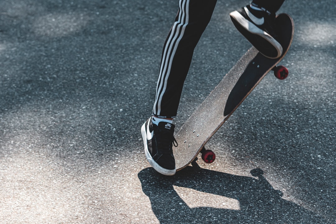 person in black and white track pants and black and white nike sneakers