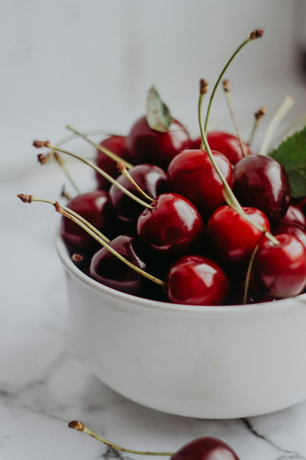 cerises rouges dans un bol en céramique blanche