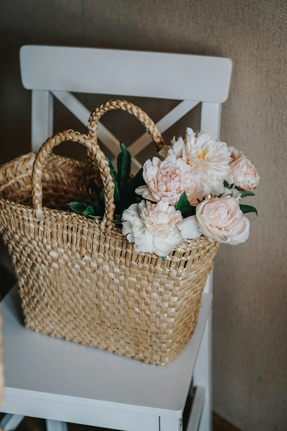 white and pink roses in brown woven basket