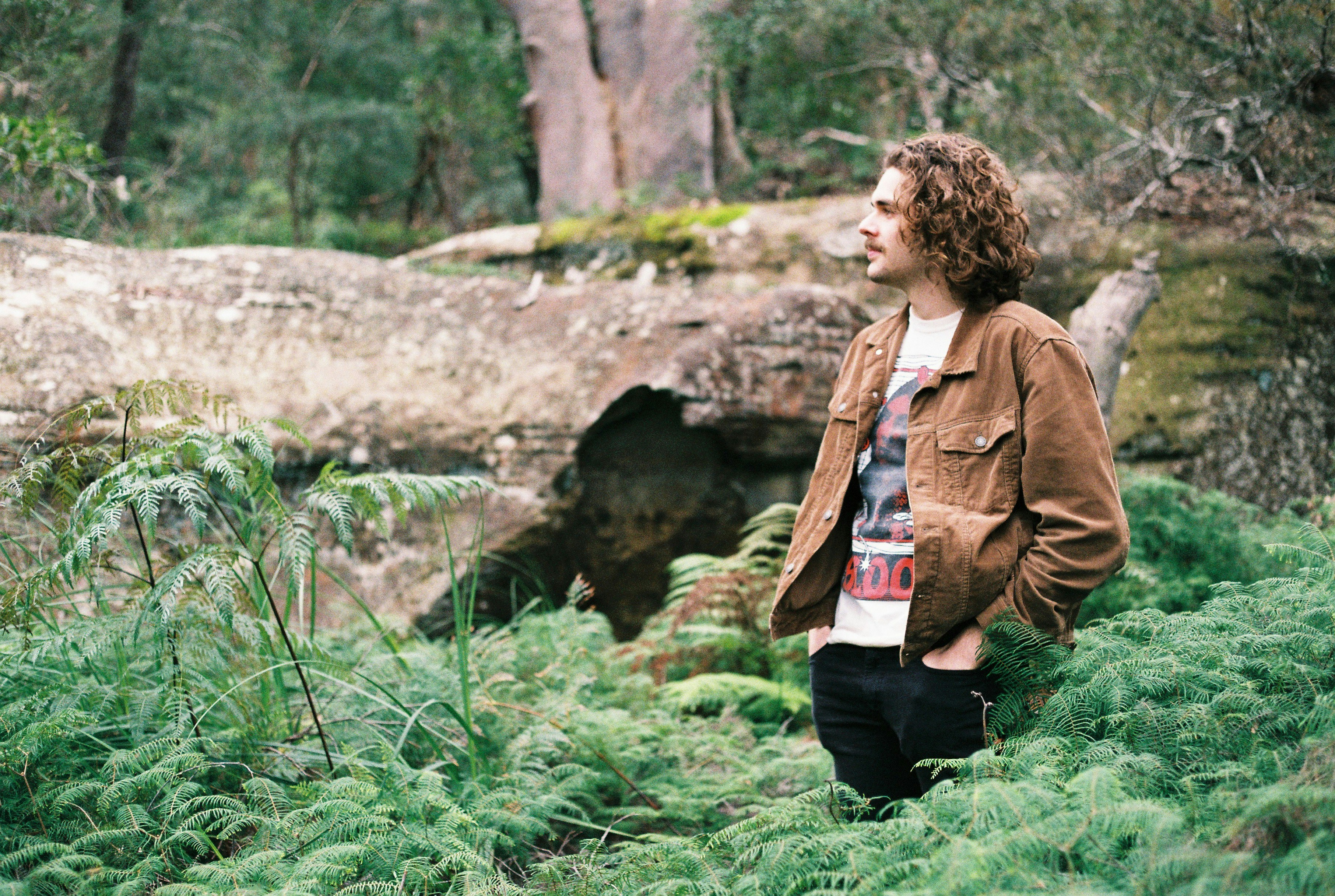 woman in brown jacket sitting on green grass during daytime