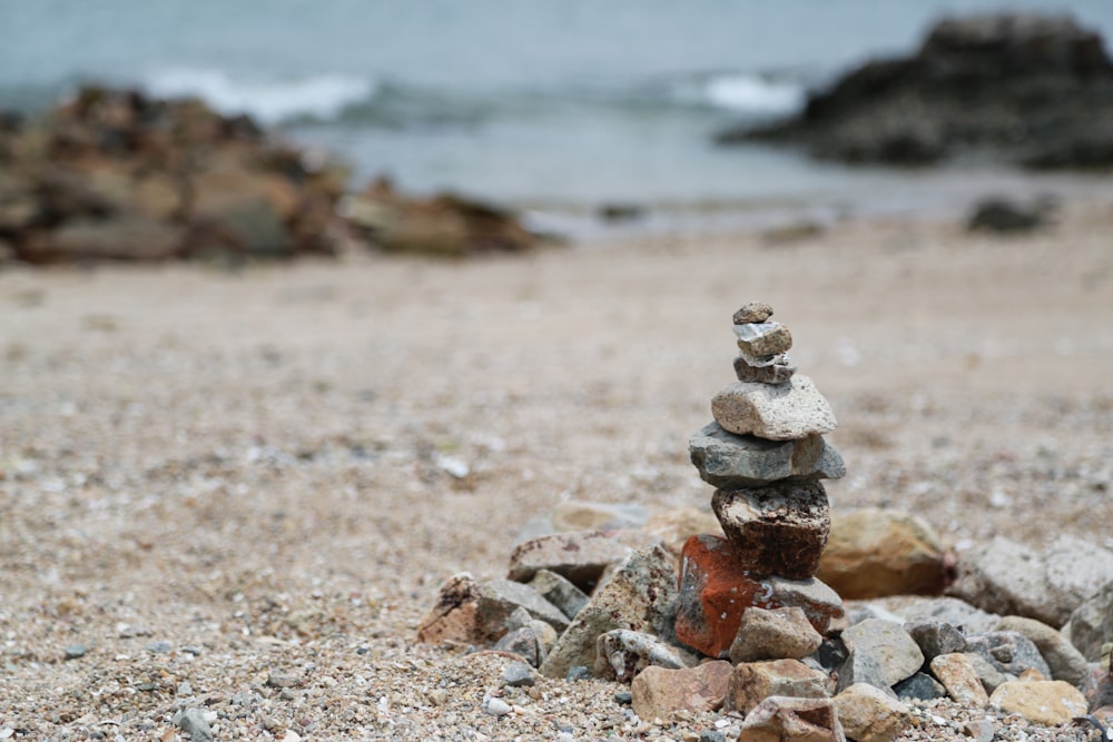 stack of stones near body of water during daytime