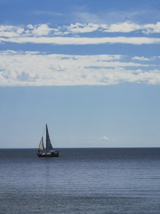 sailboat on sea under white clouds and blue sky during daytime in Gimli Canada