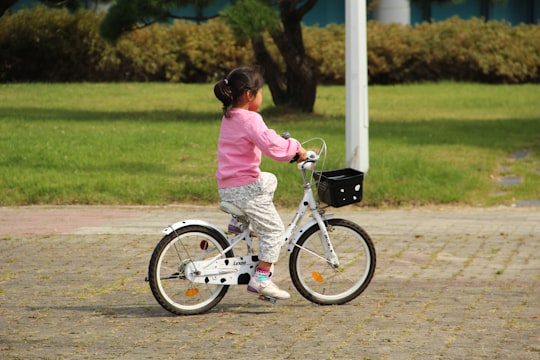 girl in pink jacket riding bicycle during daytime in Daejeon South Korea