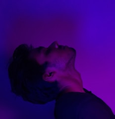 A striking portrait of Elara with glowing purple and pink accents, set against a minimalist futuristic backdrop.