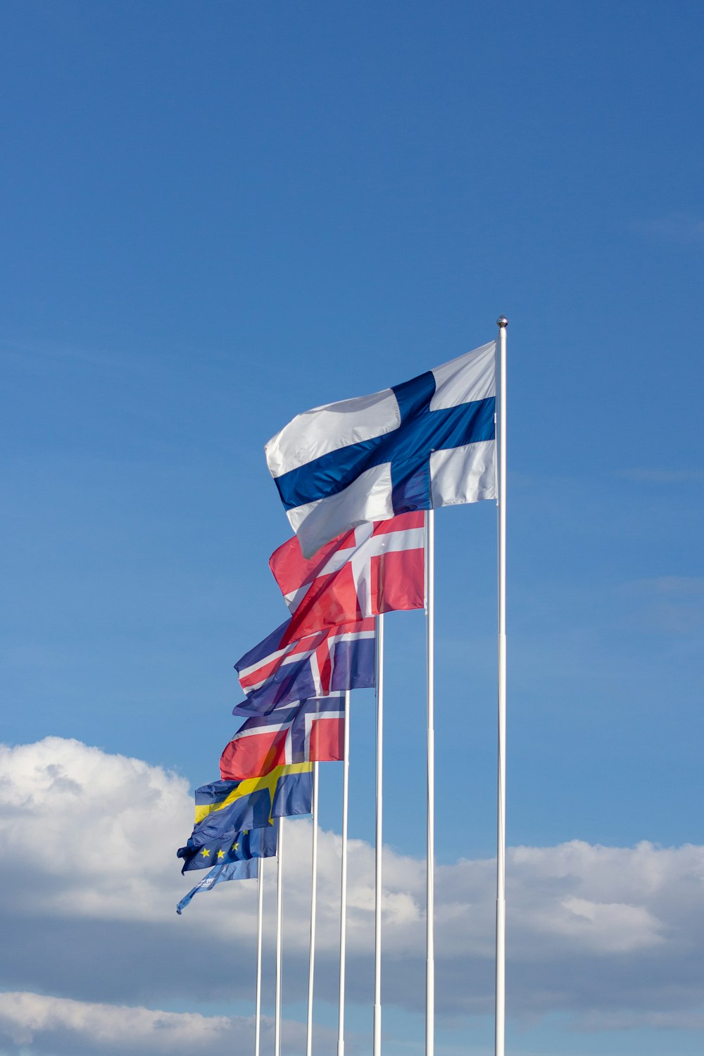 bandeira listrada vermelha e azul branca sob o céu azul durante o dia