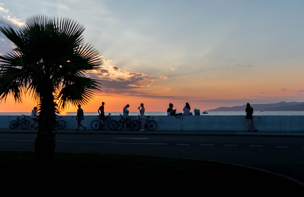 Gente montando en bicicleta en la carretera durante la puesta del sol
