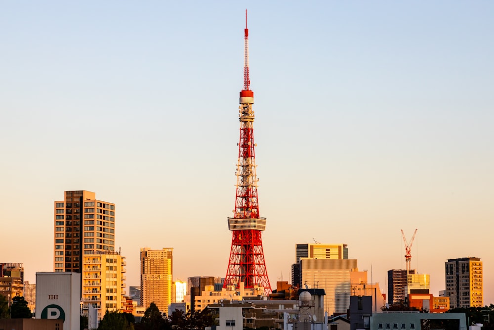 낮 동안 도시 건물 근처의 빨간색과 흰색 타워