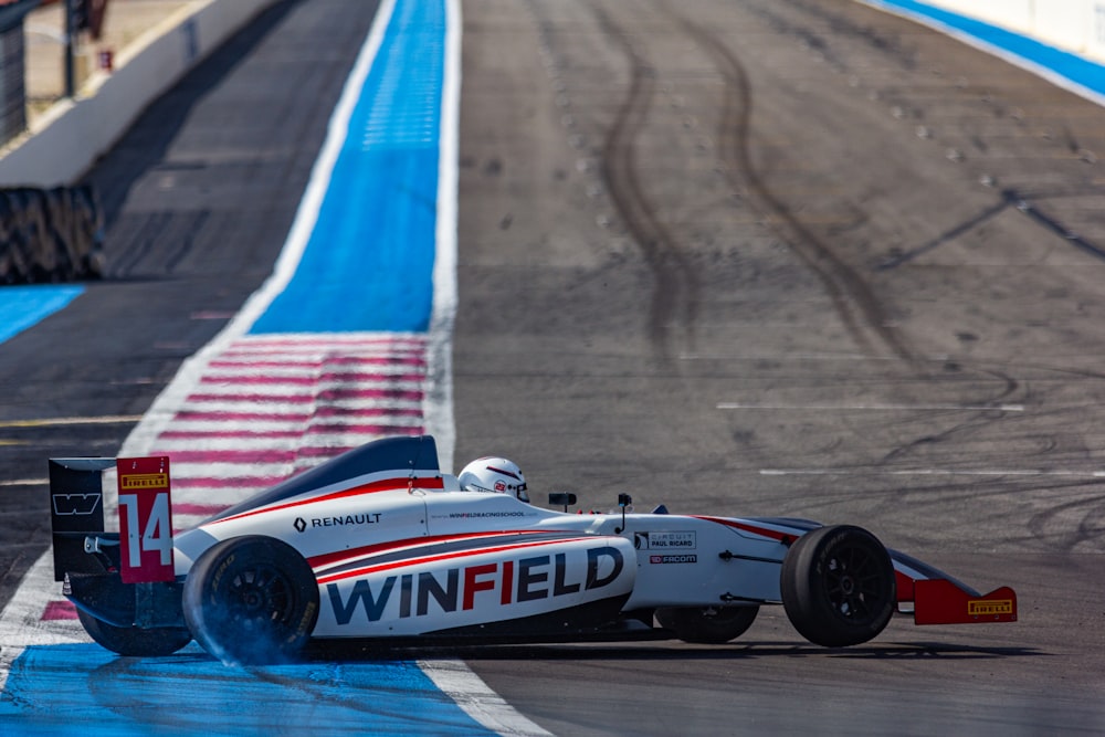 white and red f 1 car on road during daytime