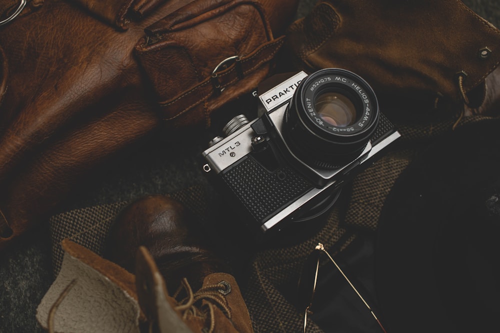 black and silver dslr camera on black leather bag