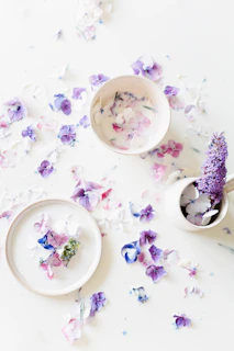 Handcrafted ceramic bowls arranged artistically with fresh flowers around.