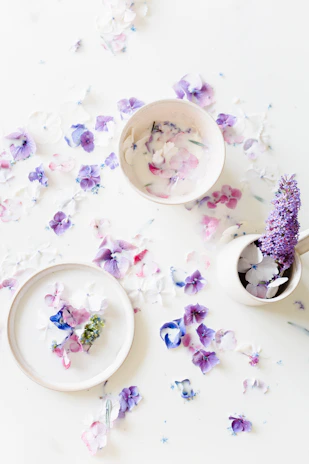 Handcrafted ceramic bowls arranged artistically with fresh flowers around.