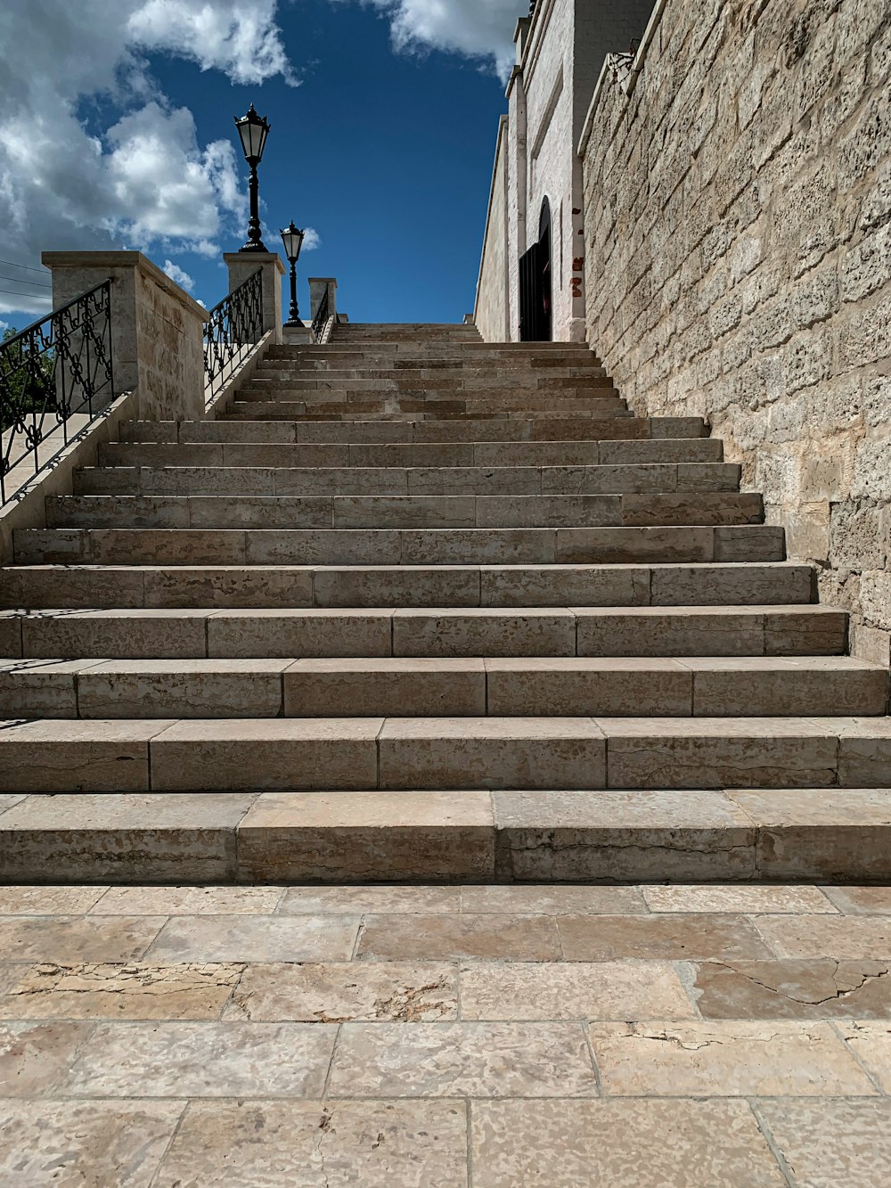 person in black jacket standing on gray concrete stairs