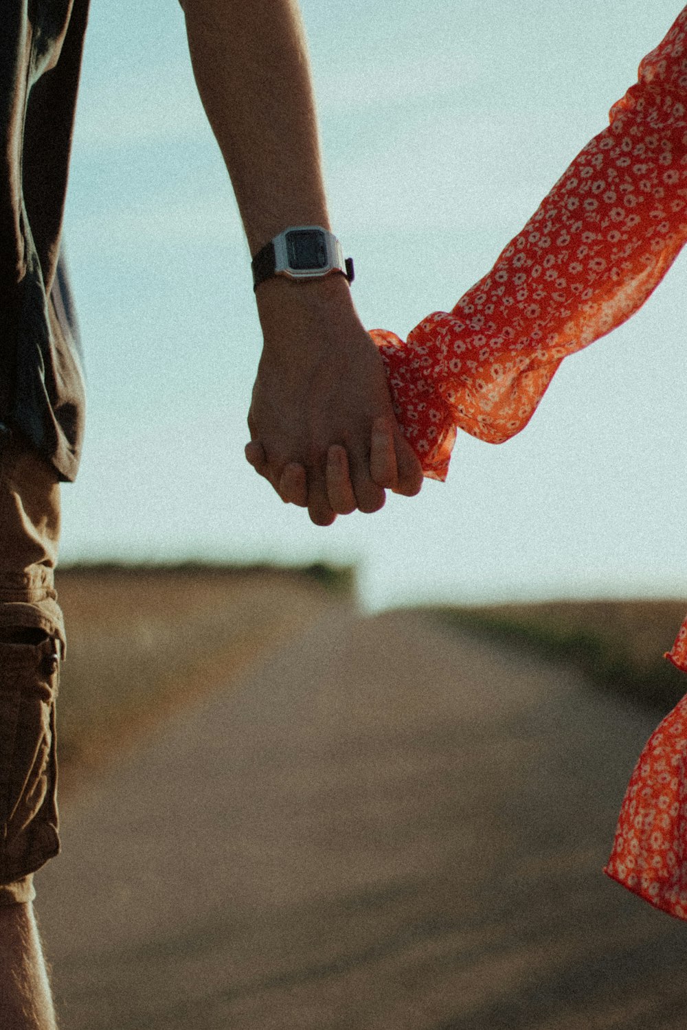 person in brown pants holding red heart shaped textile