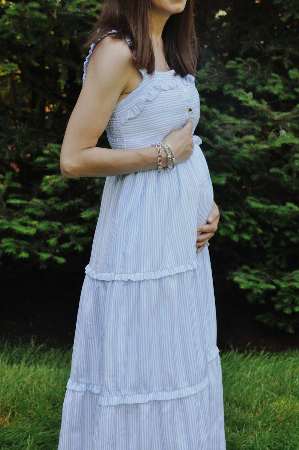 woman in white sleeveless dress standing on green grass field during daytime