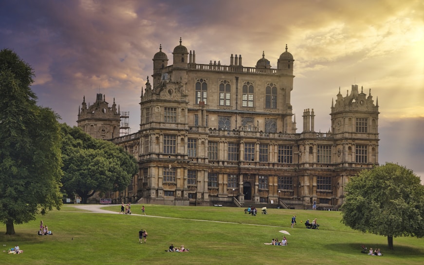 people playing soccer on green grass field near brown concrete building during daytime