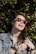 A vibrant image of a person wearing fashionable sunglasses outdoors, enjoying a sunny day.