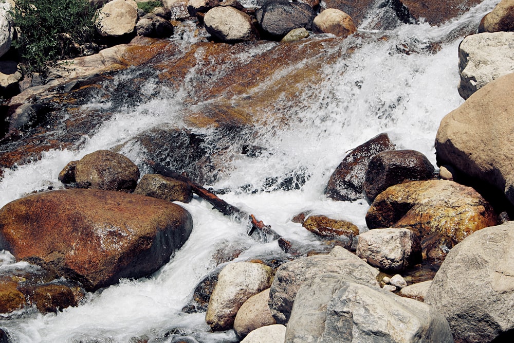 water falls on rocky shore during daytime