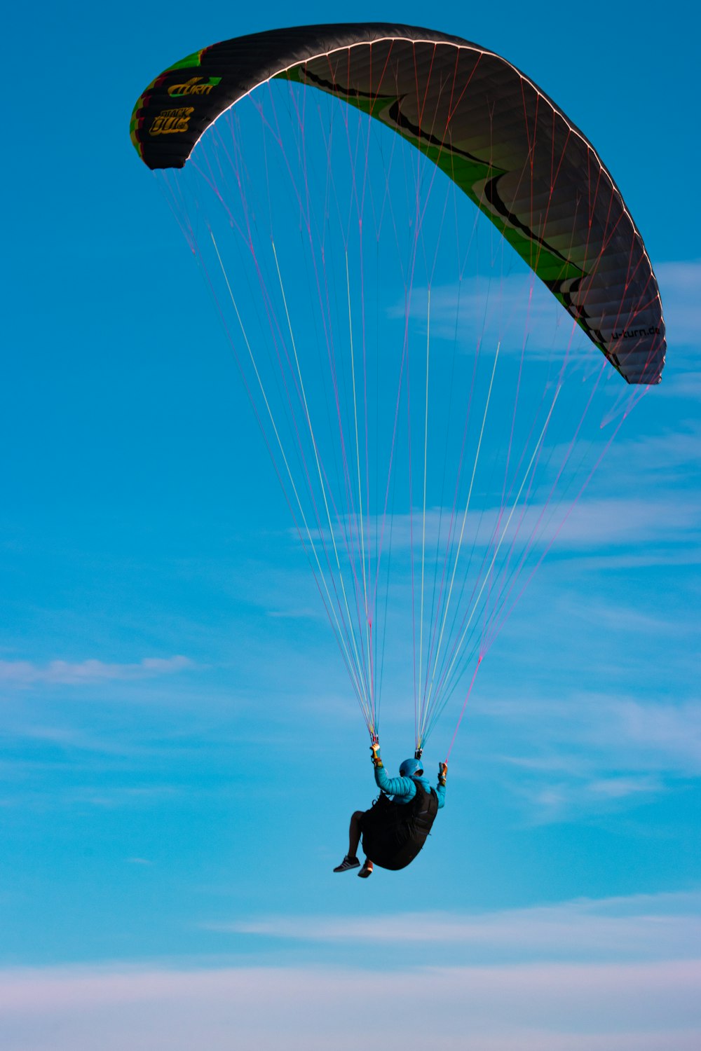 person in black jacket and black pants riding on yellow parachute