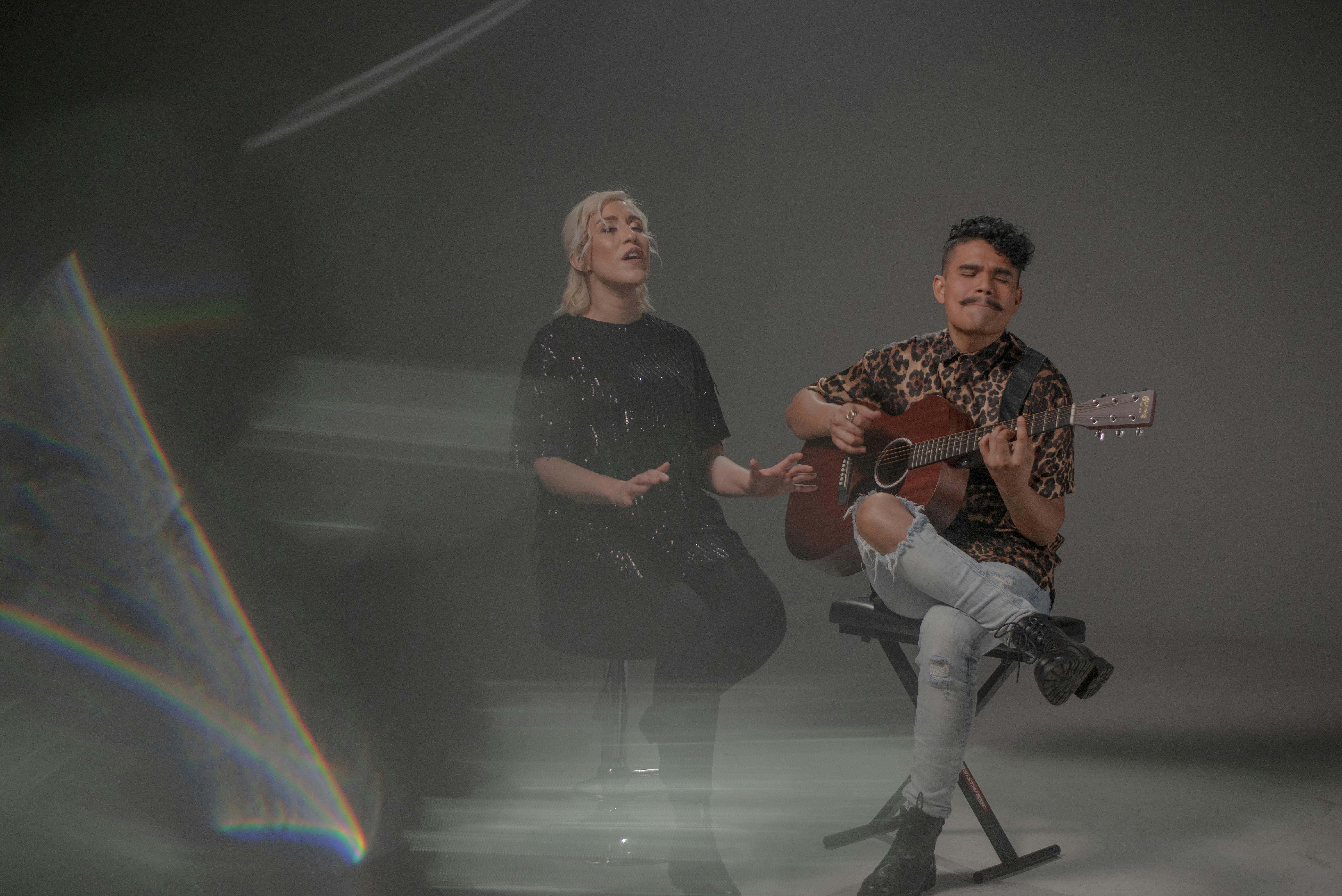 Mann in schwarz-weißem Langarmhemd sitzt neben Frau in Schwarz-Weiß lang