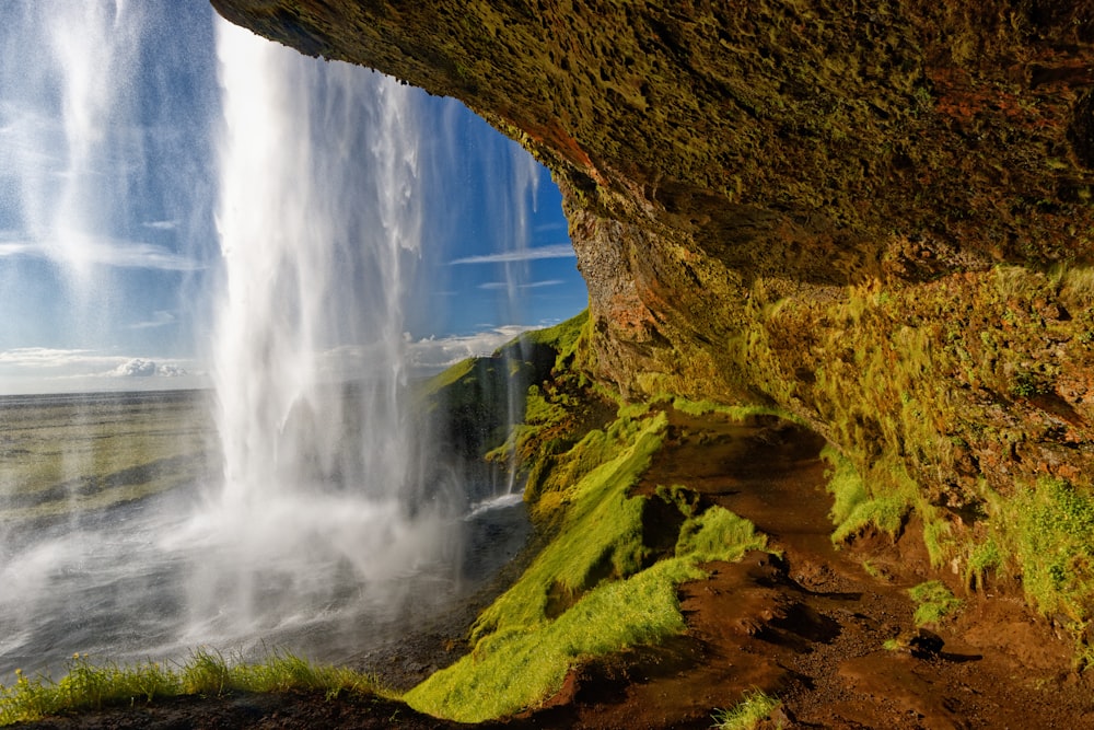 L'acqua cade nella montagna rocciosa marrone durante il giorno