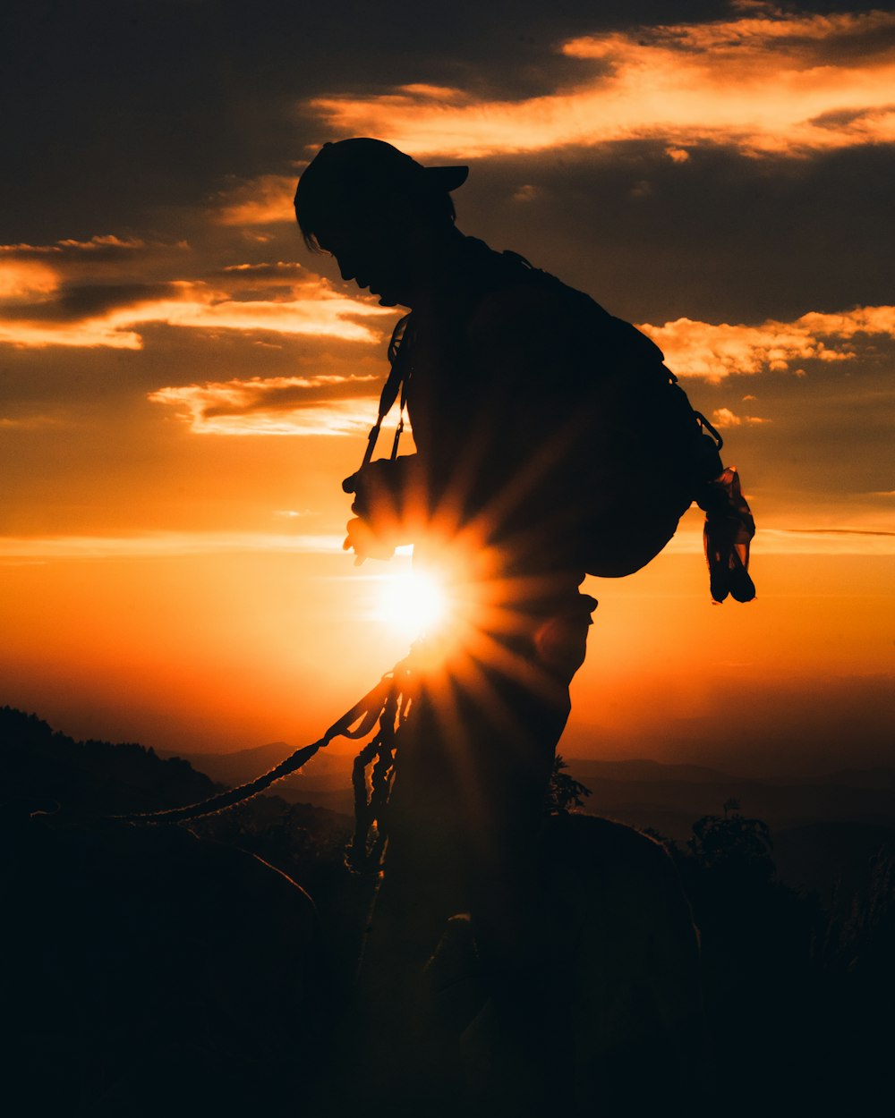 silhouette of man holding rope during sunset
