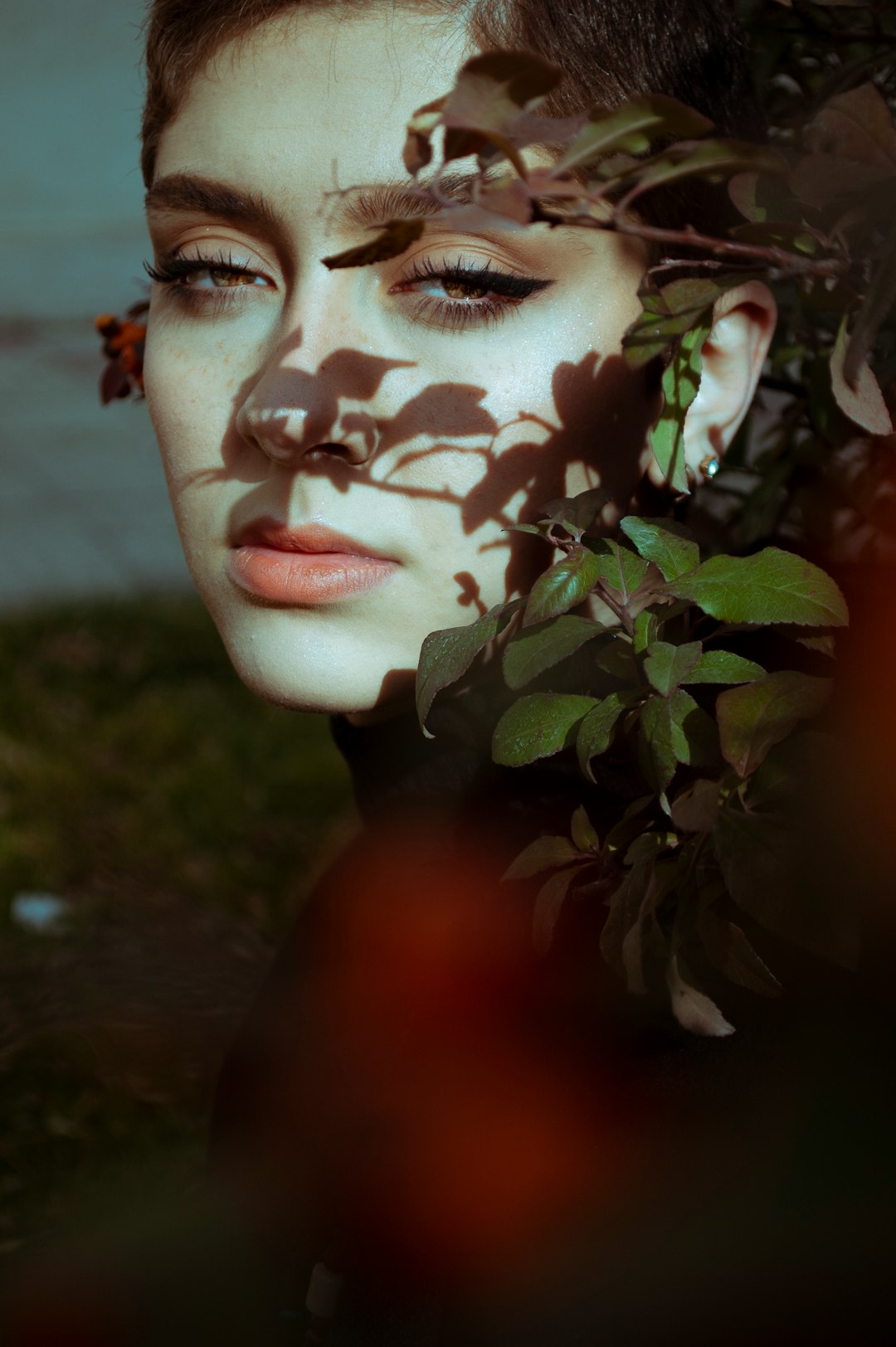 womans face with green leaves