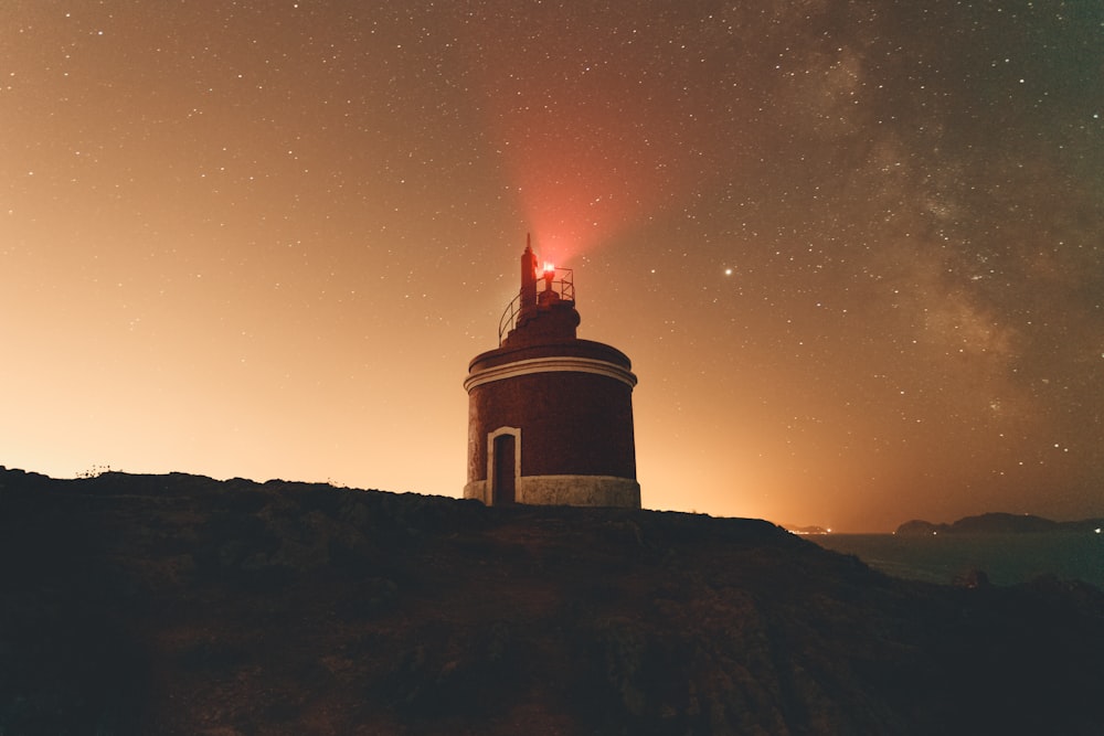 white and black lighthouse under blue sky during night time