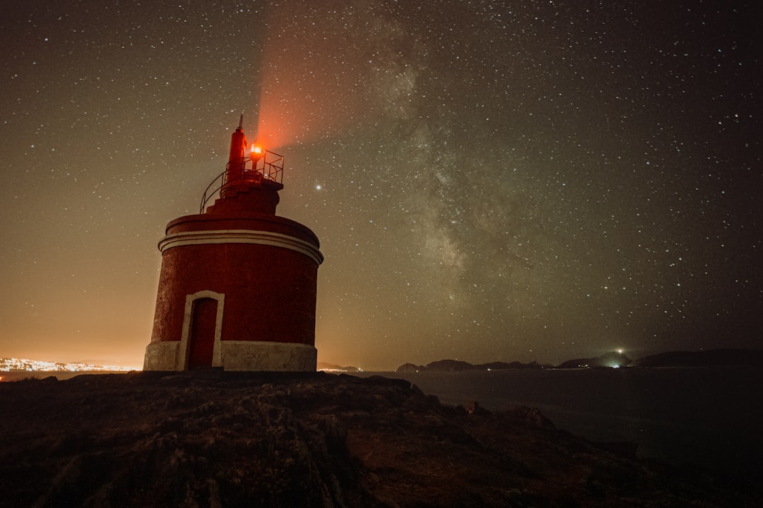 brown and white lighthouse under starry night