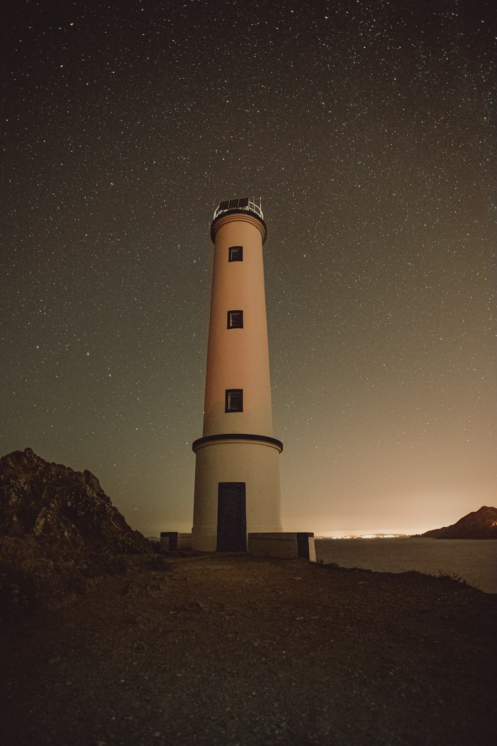 white and black lighthouse under blue sky during night time