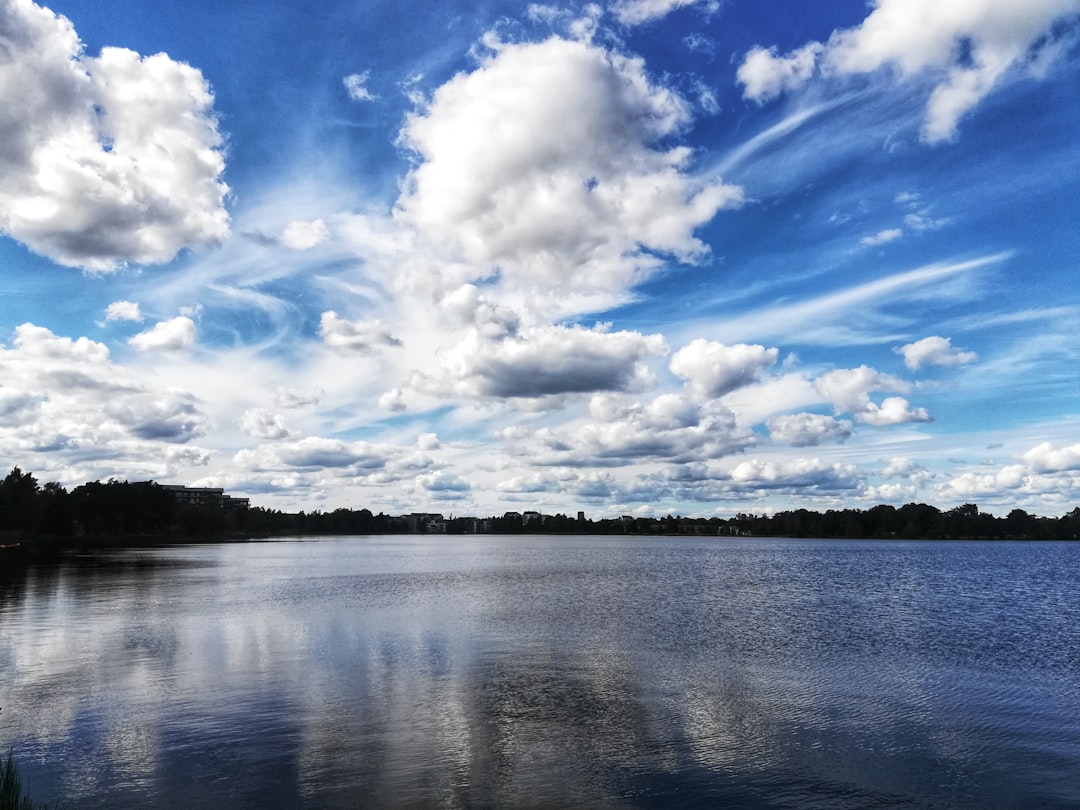 body of water under blue sky and white clouds during daytime