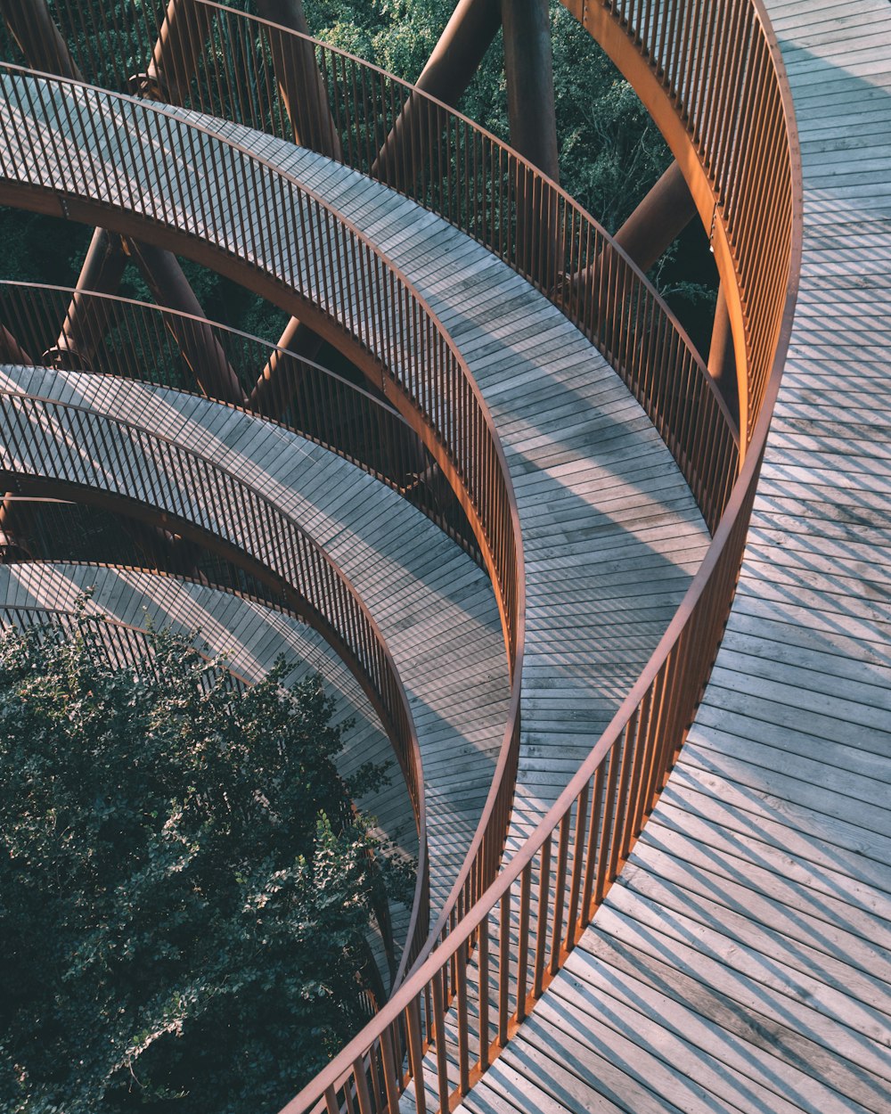 brown spiral staircase near green trees during daytime