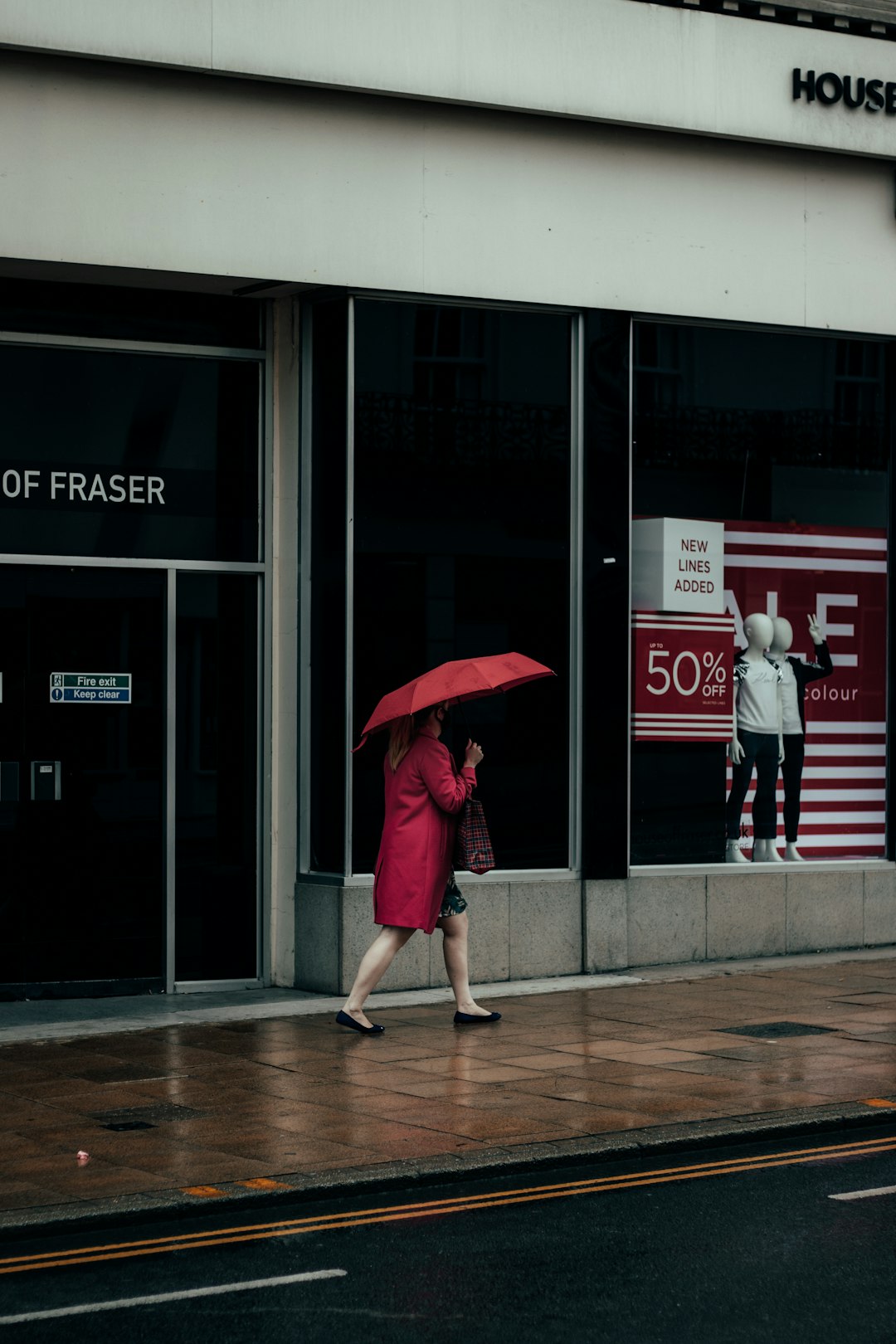 woman in red umbrella walking on sidewalk during daytime