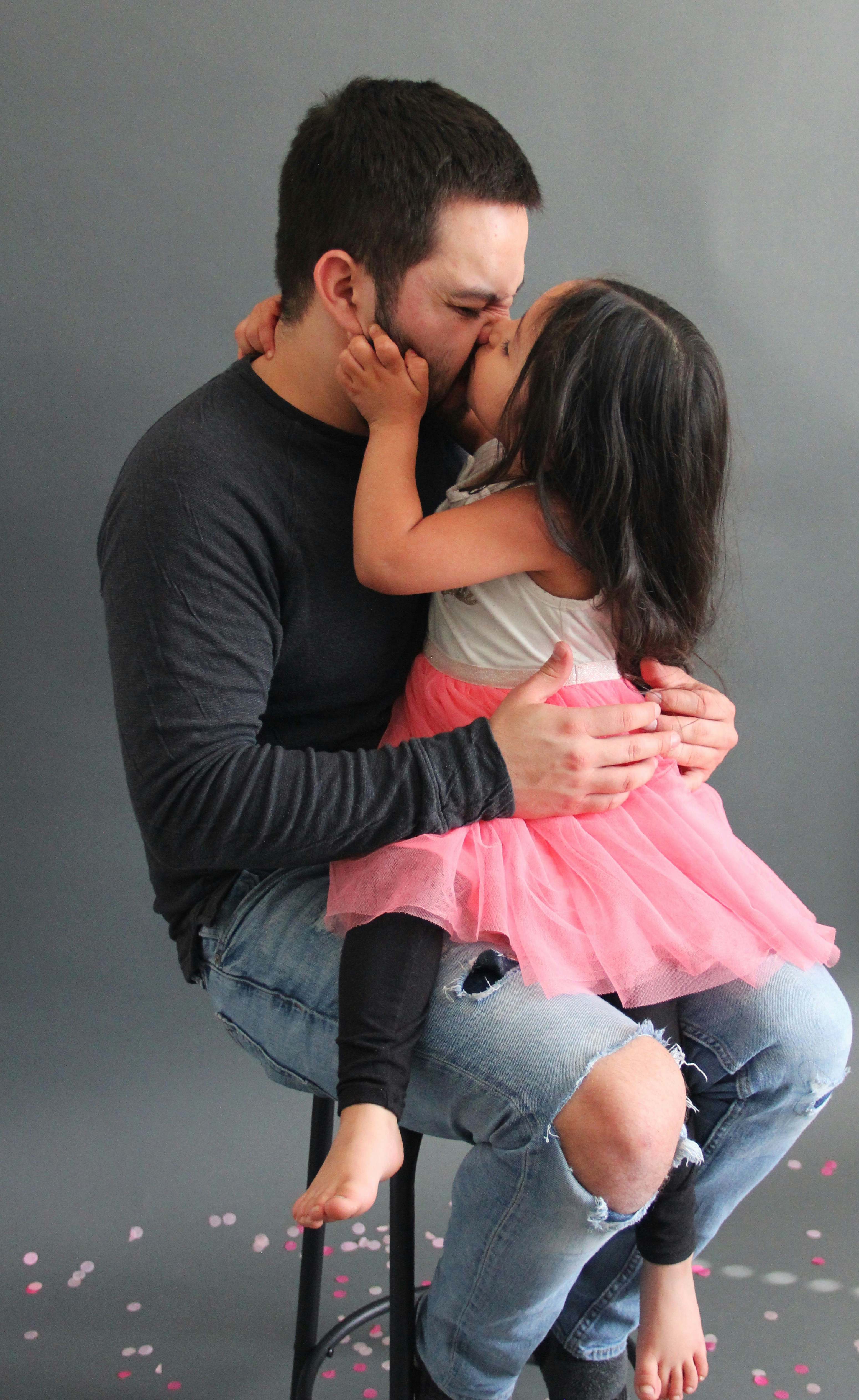 man in black long sleeve shirt kissing woman in pink dress