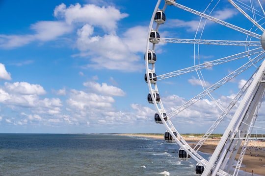 ferris wheel on beach under blue sky during daytime in Scheveningen Netherlands