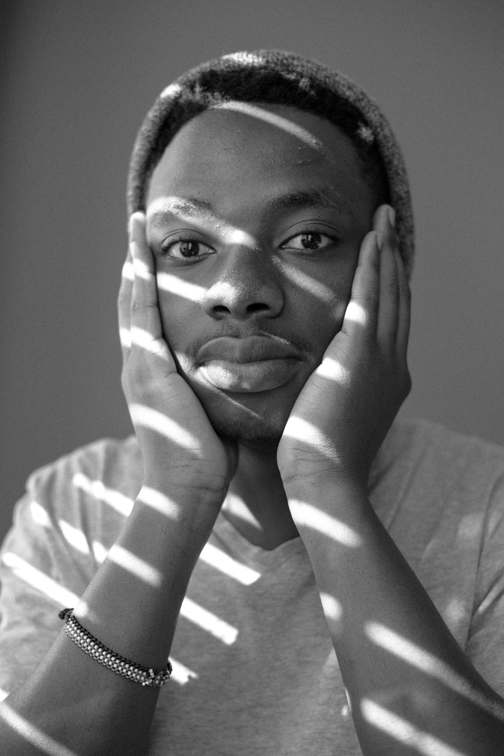 grayscale photo of woman covering her face with her hand