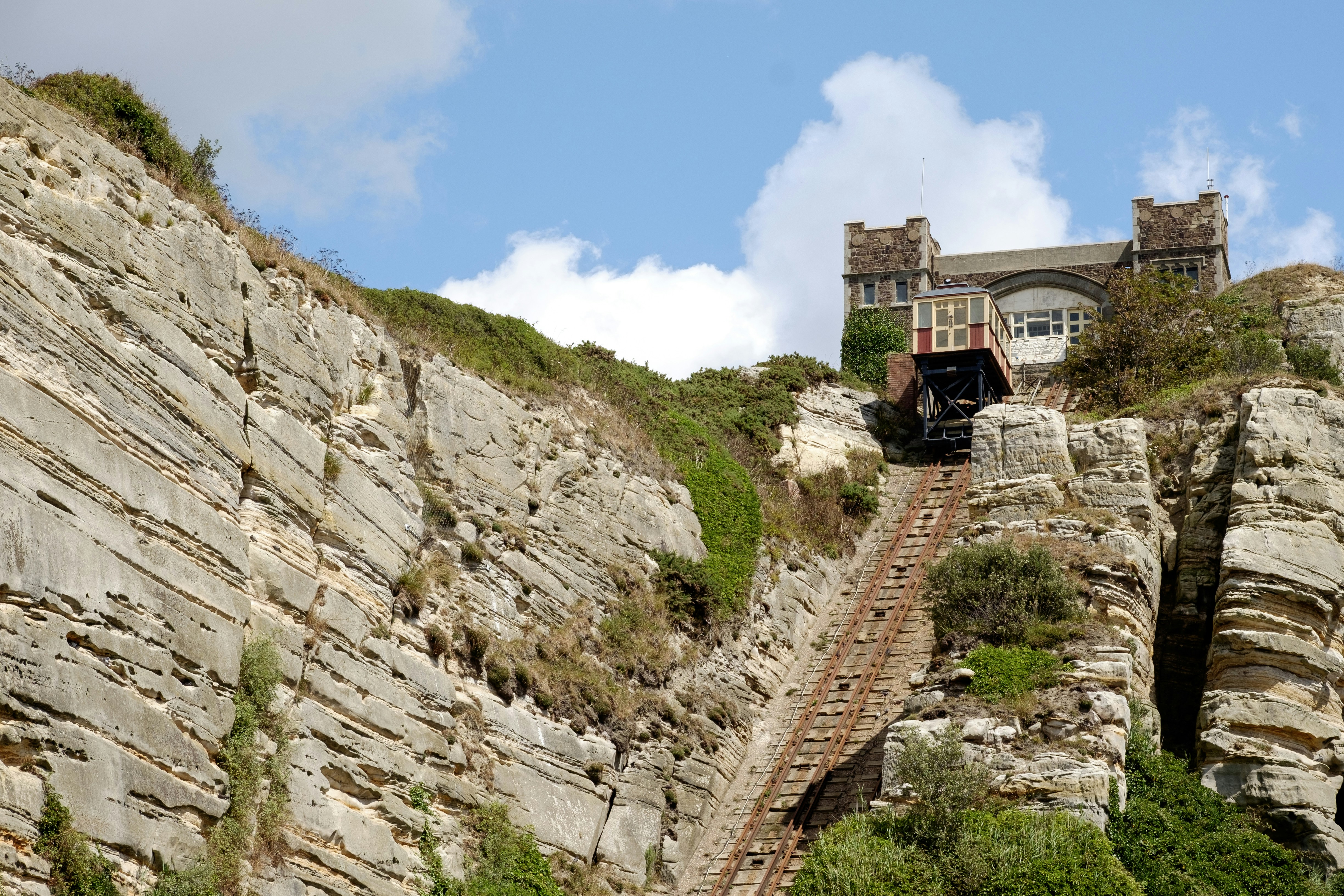 brown concrete building on rocky hill under blue sky during daytime