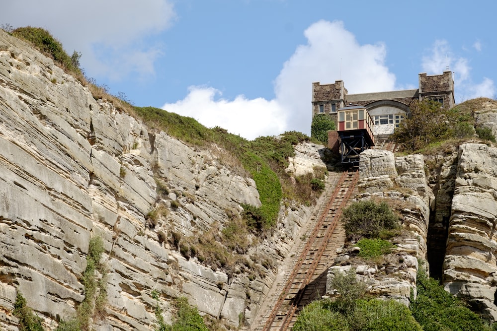 brown concrete building on rocky hill under blue sky during daytime