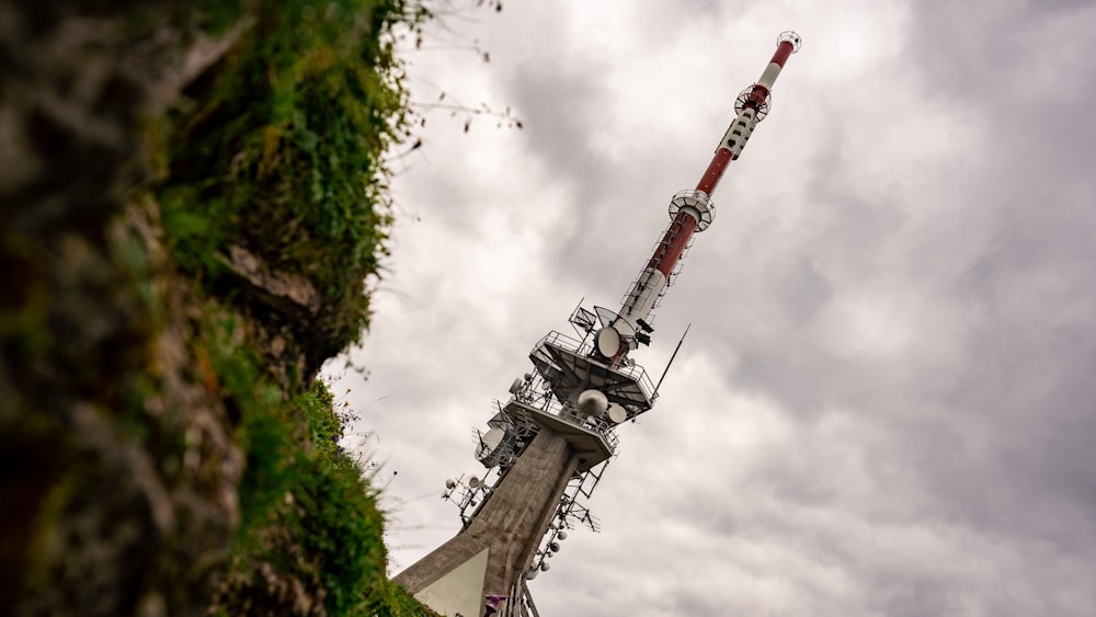 Grauer und roter Turm unter bewölktem Himmel