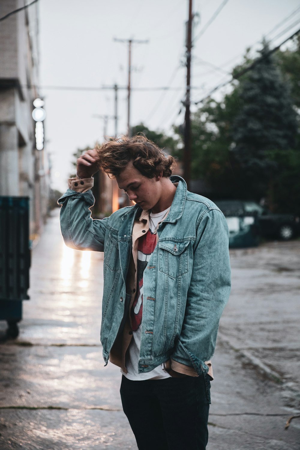 woman in blue denim jacket standing on sidewalk during daytime